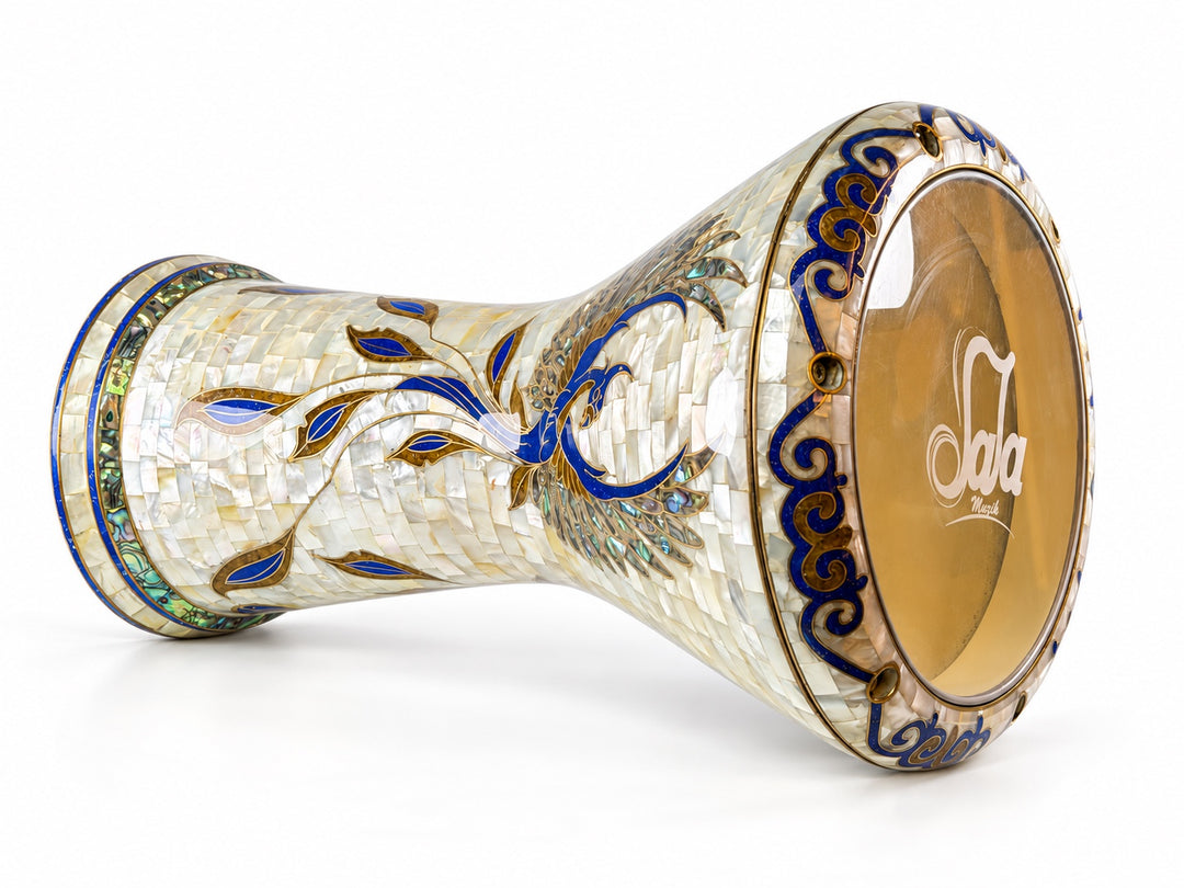 Sala Phoenix Pearl Sombaty darbuka on its side, showing the Sala-branded drumhead and a sweeping blue-and-gold bird motif on pale mosaic.